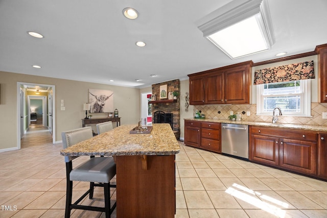 1973 Elon Ossipee Rd, Elon, NC 27244 - kitchen with stainless steel dishwasher, decorative backsplash, a kitchen breakfast bar, light tile patterned floors, and a kitchen island