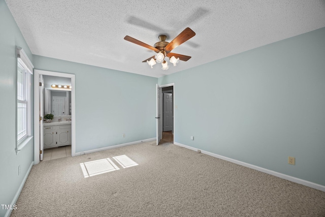 1973 Elon Ossipee Rd, Elon, NC 27244 - unfurnished bedroom with light carpet, baseboards, a textured ceiling, ensuite bath, and ceiling fan
