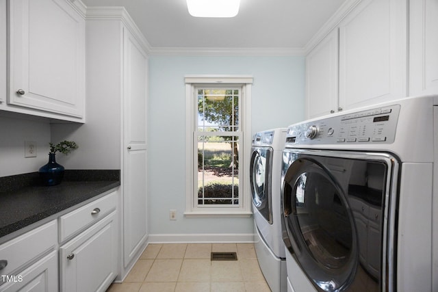1973 Elon Ossipee Rd, Elon, NC 27244 - laundry room featuring washing machine and dryer, cabinet space, baseboards, ornamental molding, and light tile patterned flooring