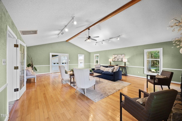 1973 Elon Ossipee Rd, Elon, NC 27244 - living area with vaulted ceiling, rail lighting, ceiling fan, light wood-style flooring, and a textured ceiling