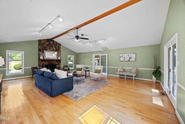 1973 Elon Ossipee Rd, Elon, NC 27244 - living room with rail lighting, vaulted ceiling, a fireplace, wood finished floors, and ceiling fan