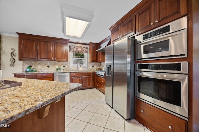 1973 Elon Ossipee Rd, Elon, NC 27244 - kitchen with stainless steel appliances, tasteful backsplash, ornamental molding, a sink, and light tile patterned floors