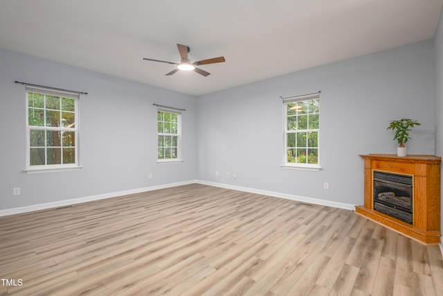 1510 Bungalow Ave, Durham, NC 27703 - unfurnished living room with plenty of natural light, light wood-type flooring, a ceiling fan, and a fireplace