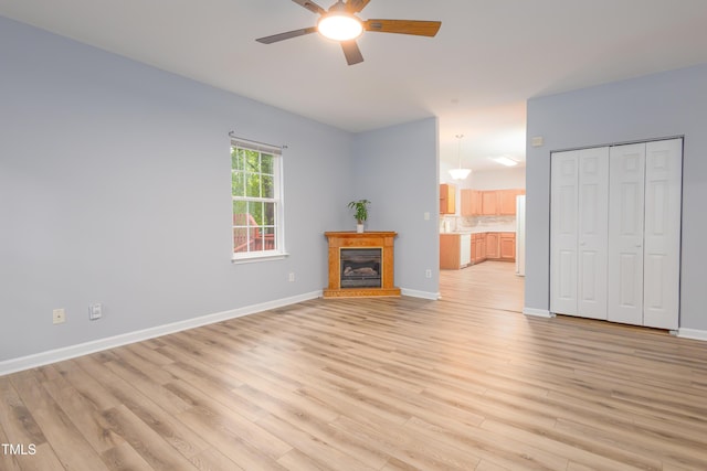 1510 Bungalow Ave, Durham, NC 27703 - unfurnished living room featuring a ceiling fan, light wood-style flooring, baseboards, and a glass covered fireplace
