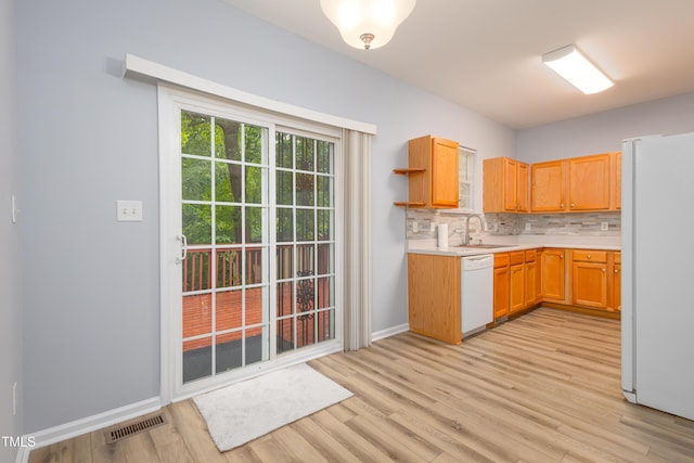 1510 Bungalow Ave, Durham, NC 27703 - kitchen with white appliances, light countertops, a sink, light wood-style flooring, and decorative backsplash