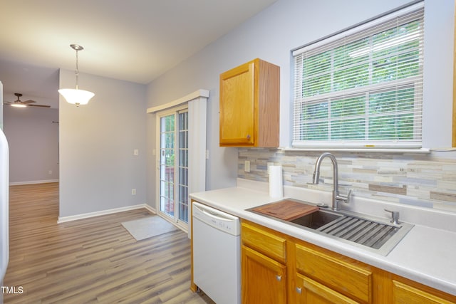 1510 Bungalow Ave, Durham, NC 27703 - kitchen with white dishwasher, a sink, tasteful backsplash, light wood-style floors, and light countertops