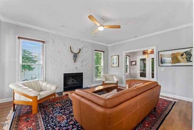 4408 Queenstown Ct, Raleigh, NC 27612 - living area with a premium fireplace, wood finished floors, ornamental molding, ceiling fan, and baseboards