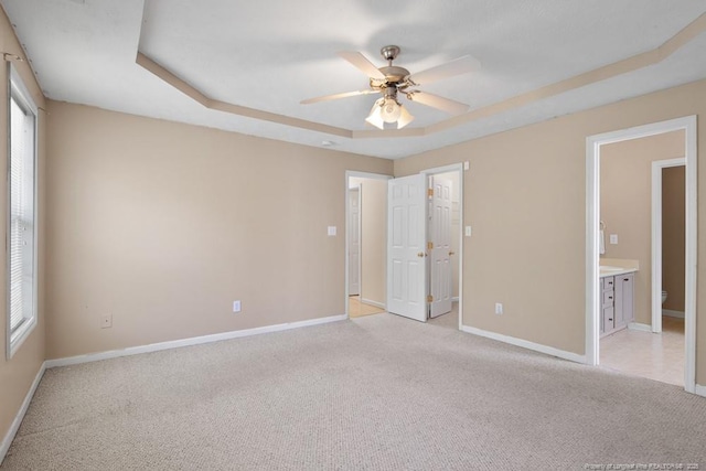 122 Van Buren Dr, Raeford, NC 28376 - unfurnished bedroom with a tray ceiling, light colored carpet, and baseboards