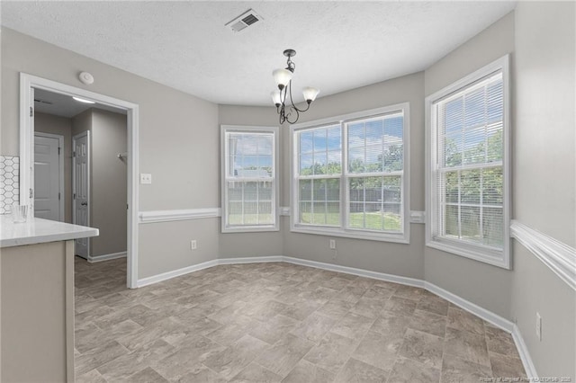 4404 Bunkers Bay Ln, Parkton, NC 28371 - unfurnished dining area with a chandelier, baseboards, and a textured ceiling