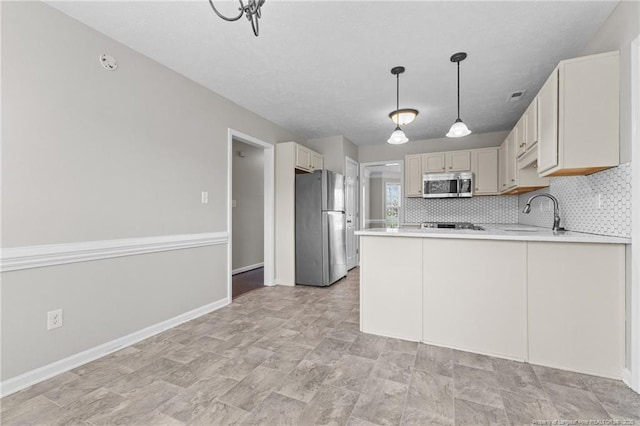 4404 Bunkers Bay Ln, Parkton, NC 28371 - kitchen with appliances with stainless steel finishes, a peninsula, a sink, light countertops, and pendant lighting