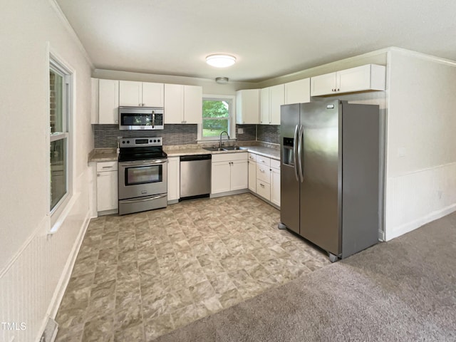 1413 Chamblee Rd, Zebulon, NC 27597 - kitchen with appliances with stainless steel finishes, a sink, white cabinets, and backsplash