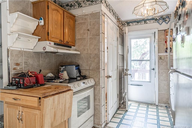 8212 Main St, West End, NC 27376 - kitchen featuring white appliances, under cabinet range hood, light floors, a chandelier, and tile walls