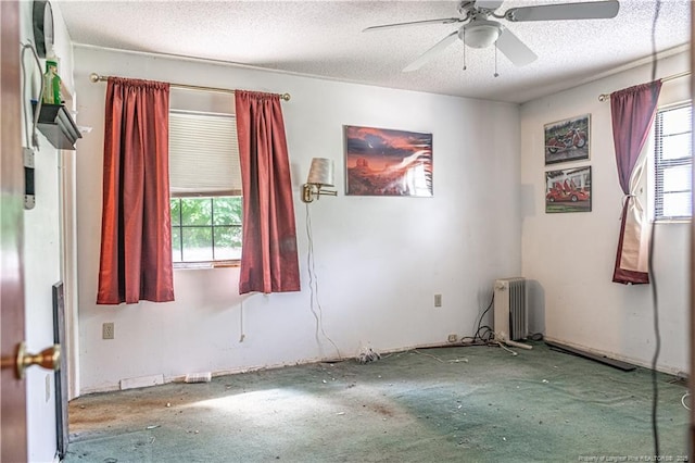 8212 Main St, West End, NC 27376 - empty room with radiator, ceiling fan, and a textured ceiling