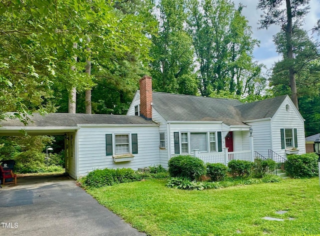 1609 Cypress Dr, Henderson, NC 27536 - view of front facade with asphalt driveway, a chimney, a front lawn, and an attached carport