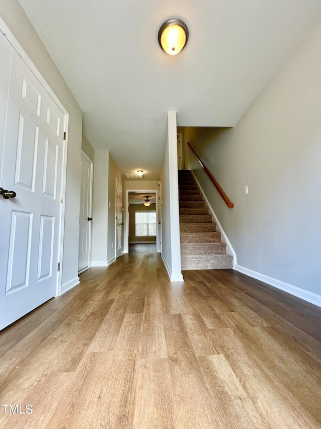 2118 Kedvale Ave, Raleigh, NC 27617 - unfurnished living room featuring wood finished floors, stairway, baseboards, and ceiling fan
