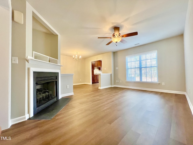 2118 Kedvale Ave, Raleigh, NC 27617 - unfurnished living room with ceiling fan, a fireplace with flush hearth, wood finished floors, a chandelier, and baseboards