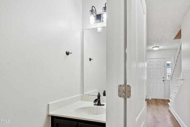 128 Newton Ct, Raeford, NC 28376 - bathroom with vanity, a textured ceiling, wood finished floors, and baseboards