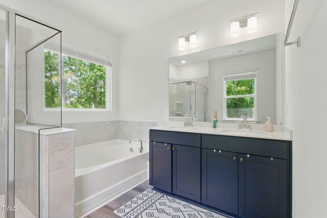 187 Harpers Landing Rd, Garner, NC 27529 - full bath with double vanity, a bath, a shower stall, and wood finished floors