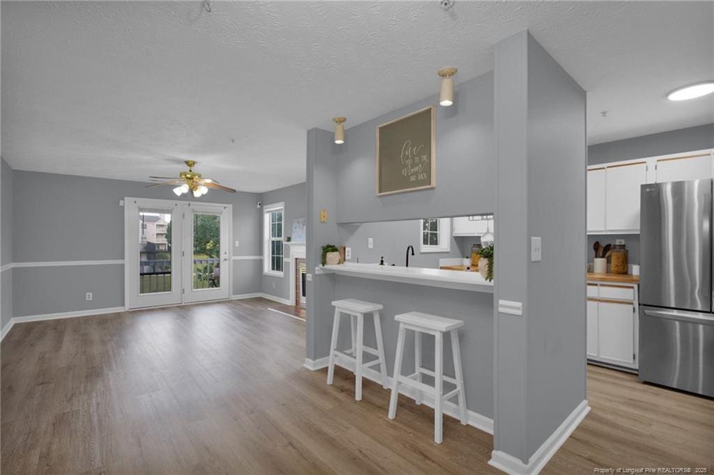 216 Waterdown Dr Unit 8, Fayetteville, NC 28314 - kitchen featuring freestanding refrigerator, a kitchen bar, light wood-type flooring, and white cabinets