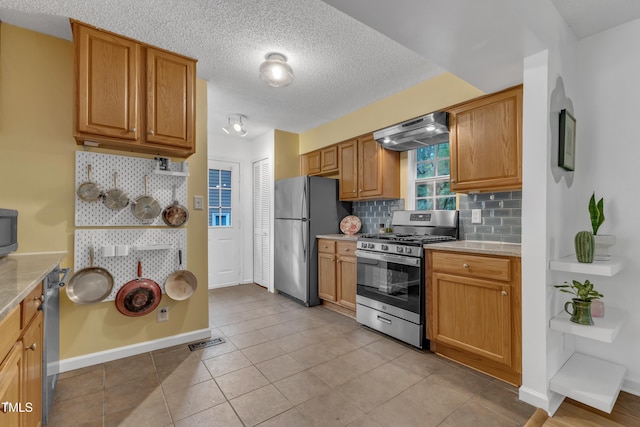 4009 Olde Coach Rd, Durham, NC 27707 - kitchen with appliances with stainless steel finishes, ventilation hood, tasteful backsplash, a textured ceiling, and baseboards