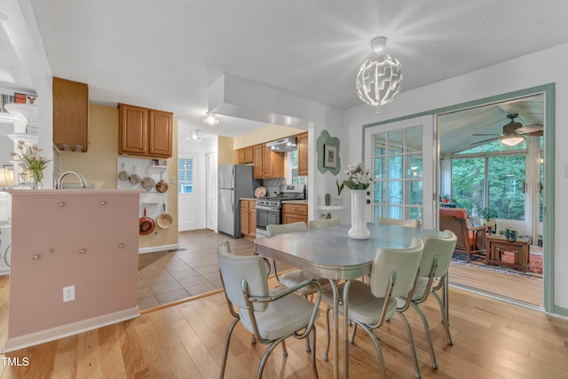 4009 Olde Coach Rd, Durham, NC 27707 - dining room with light wood-type flooring, a ceiling fan, a chandelier, and baseboards