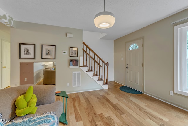 4009 Olde Coach Rd, Durham, NC 27707 - foyer entrance featuring light wood-style flooring, stairway, a textured ceiling, and baseboards