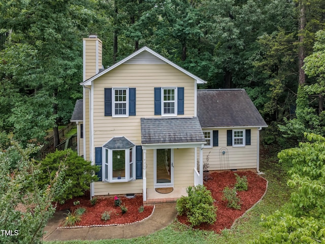 4009 Olde Coach Rd, Durham, NC 27707 - view of front of home with a chimney, a shingled roof, covered porch, and a wooded view