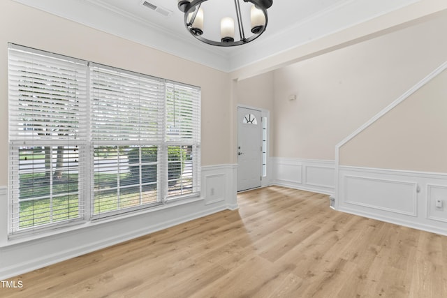 107 Woolard Way, Apex, NC 27502 - foyer with a chandelier, a wainscoted wall, light wood-style flooring, and ornamental molding