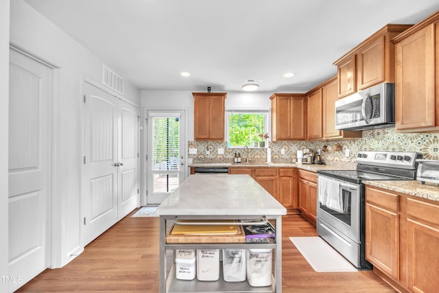 537 Hobkirks Pl, Durham, NC 27704 - kitchen with stainless steel appliances, backsplash, light wood-type flooring, and recessed lighting