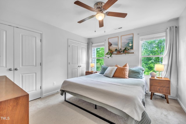 537 Hobkirks Pl, Durham, NC 27704 - bedroom featuring two closets, light colored carpet, baseboards, and ceiling fan