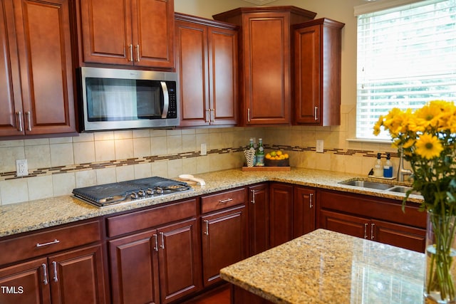 825 Fulworth Ave, Wake Forest, NC 27587 - kitchen with appliances with stainless steel finishes, reddish brown cabinets, decorative backsplash, and light stone counters