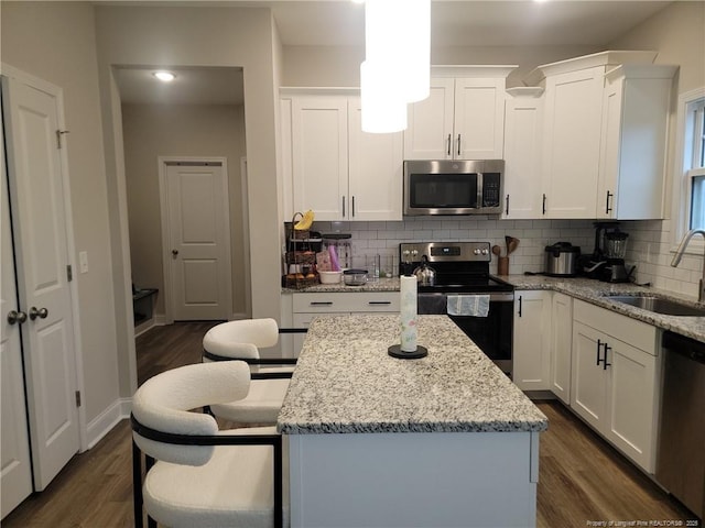 112 Nairn St, Fayetteville, NC 28311 - kitchen with appliances with stainless steel finishes, a sink, dark wood-type flooring, white cabinets, and decorative backsplash