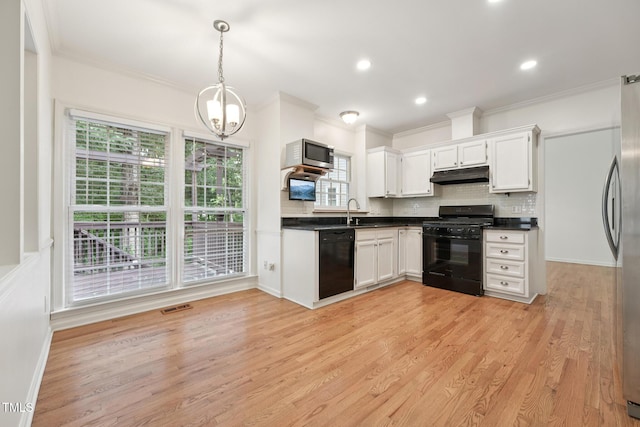 111 Catherwood Pl, Cary, NC 27518 - kitchen with black appliances, under cabinet range hood, dark countertops, healthy amount of natural light, and crown molding