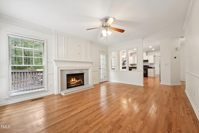 111 Catherwood Pl, Cary, NC 27518 - unfurnished living room with plenty of natural light, a glass covered fireplace, a ceiling fan, ornamental molding, and light wood finished floors