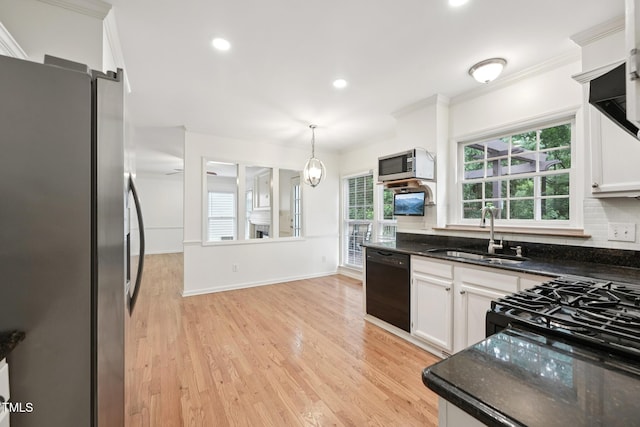 111 Catherwood Pl, Cary, NC 27518 - kitchen featuring stainless steel appliances, a sink, white cabinets, pendant lighting, and ornamental molding