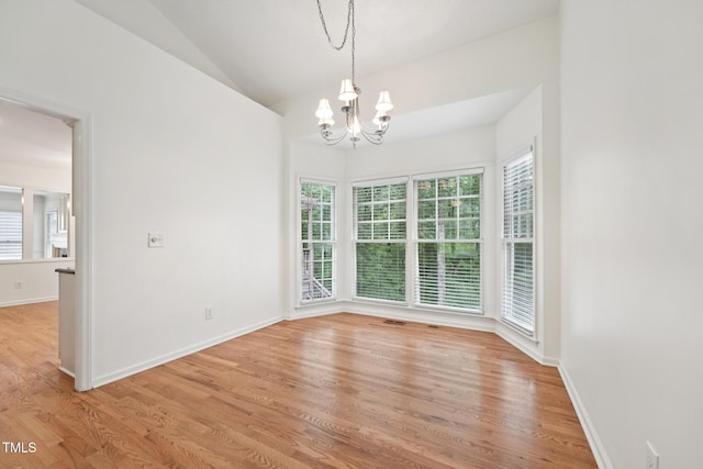 111 Catherwood Pl, Cary, NC 27518 - unfurnished dining area featuring a chandelier, plenty of natural light, light wood-type flooring, and vaulted ceiling