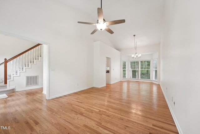 111 Catherwood Pl, Cary, NC 27518 - unfurnished living room with high vaulted ceiling, stairway, a chandelier, light wood-style floors, and ceiling fan