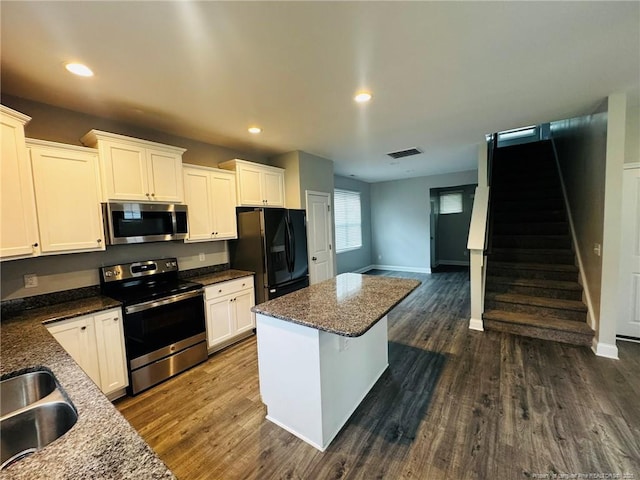4179 Overhills Rd, Spring Lake, NC 28390 - kitchen featuring appliances with stainless steel finishes, a center island, baseboards, dark wood-style floors, and recessed lighting