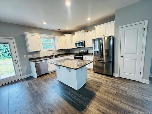 4179 Overhills Rd, Spring Lake, NC 28390 - kitchen featuring appliances with stainless steel finishes, white cabinets, dark wood finished floors, a center island, and recessed lighting