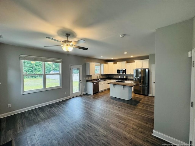4179 Overhills Rd, Spring Lake, NC 28390 - kitchen featuring stainless steel appliances, baseboards, a sink, dark countertops, and a kitchen island