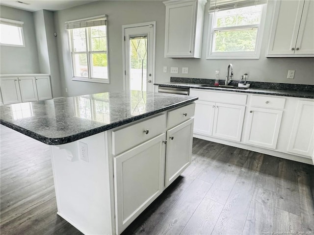 4179 Overhills Rd, Spring Lake, NC 28390 - kitchen with a sink, dark wood-type flooring, a kitchen island, dark stone counters, and white cabinetry