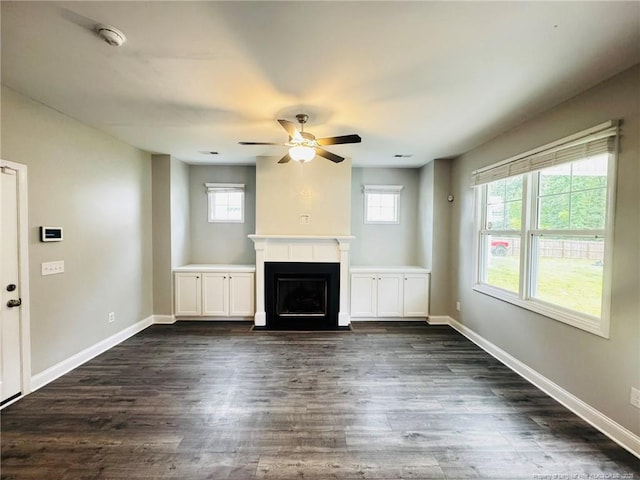 4179 Overhills Rd, Spring Lake, NC 28390 - unfurnished living room with plenty of natural light, a ceiling fan, a fireplace with flush hearth, and dark wood-style flooring