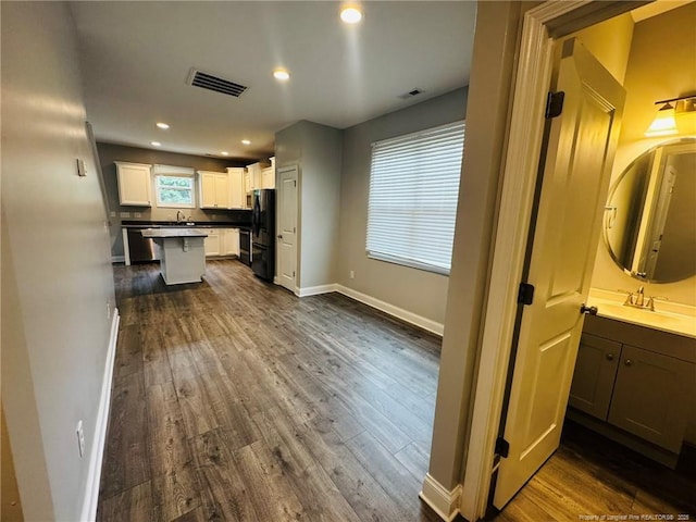 4179 Overhills Rd, Spring Lake, NC 28390 - kitchen featuring freestanding refrigerator, dark wood finished floors, a sink, white cabinets, and baseboards