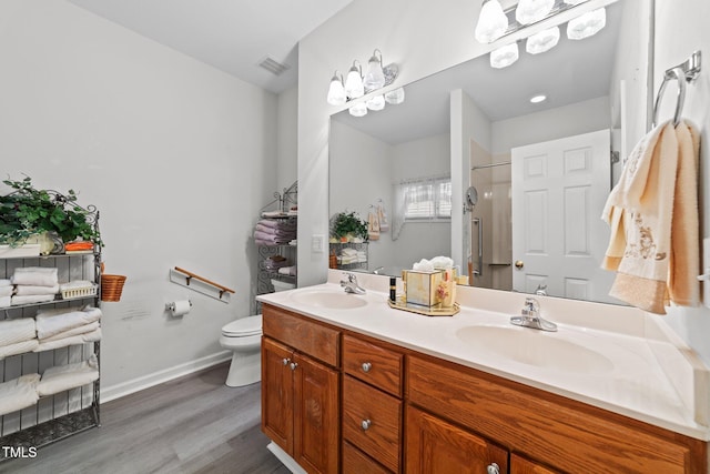 2313 Filigree Ct, Raleigh, NC 27614 - bathroom with double vanity, wood finished floors, a shower with door, toilet, and baseboards