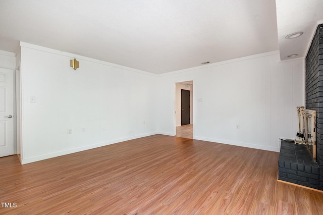 134 Chateau Rd, Durham, NC 27704 - unfurnished living room featuring light wood-type flooring, baseboards, a fireplace, and ornamental molding