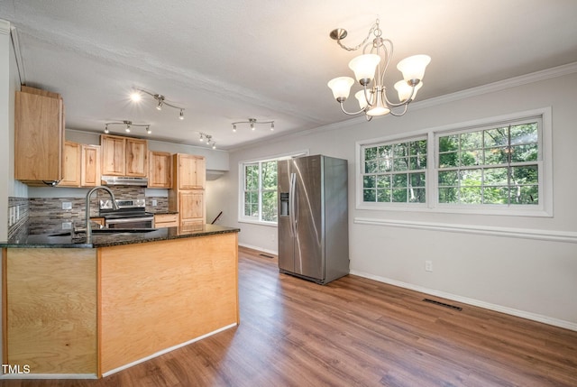 134 Chateau Rd, Durham, NC 27704 - kitchen featuring stainless steel appliances, under cabinet range hood, a sink, wood finished floors, and a chandelier