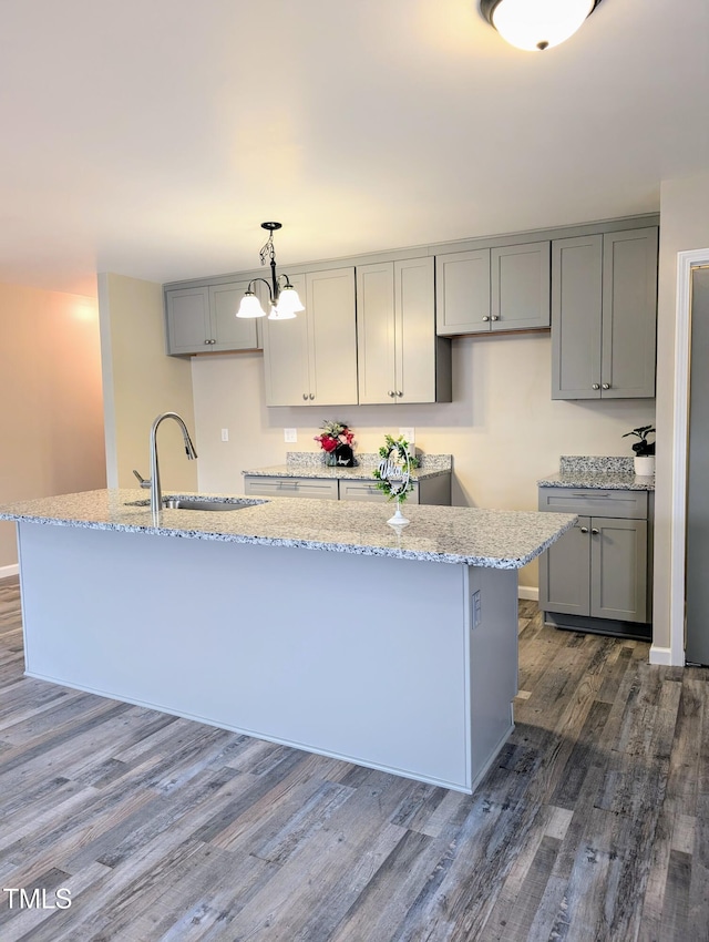 1602 Fairground Rd, Dunn, NC 28334 - kitchen with a sink, gray cabinets, dark wood-style floors, a center island with sink, and light stone countertops
