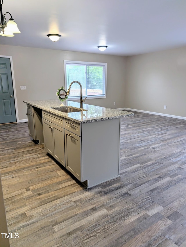 1602 Fairground Rd, Dunn, NC 28334 - kitchen with a sink, dark wood-type flooring, a kitchen island with sink, light stone countertops, and gray cabinetry