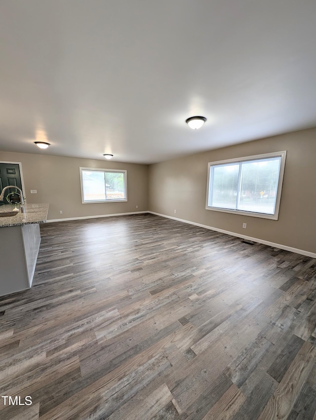 1602 Fairground Rd, Dunn, NC 28334 - unfurnished living room featuring dark wood-style flooring, a sink, and baseboards