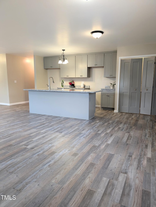 1602 Fairground Rd, Dunn, NC 28334 - kitchen featuring gray cabinets, wood finished floors, baseboards, and light stone countertops